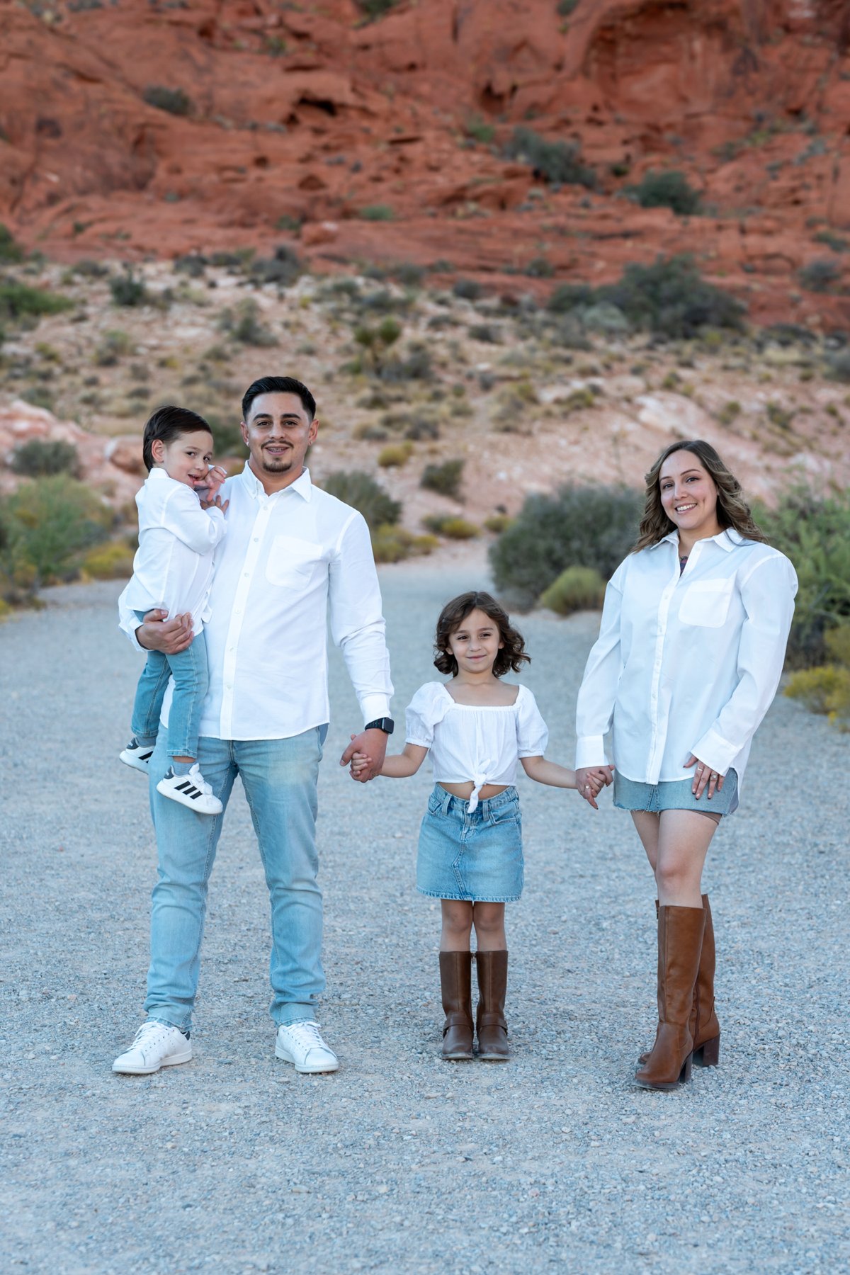 Family standing together in front of red-rock desert scenery