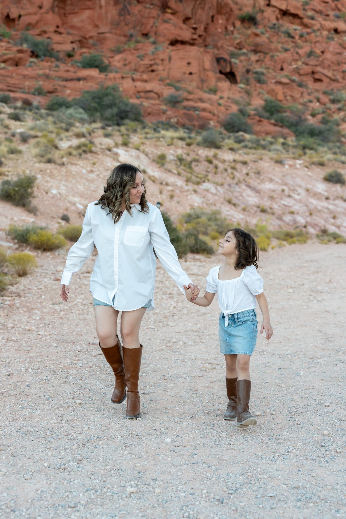 Mother and daughter walking together along a desert path