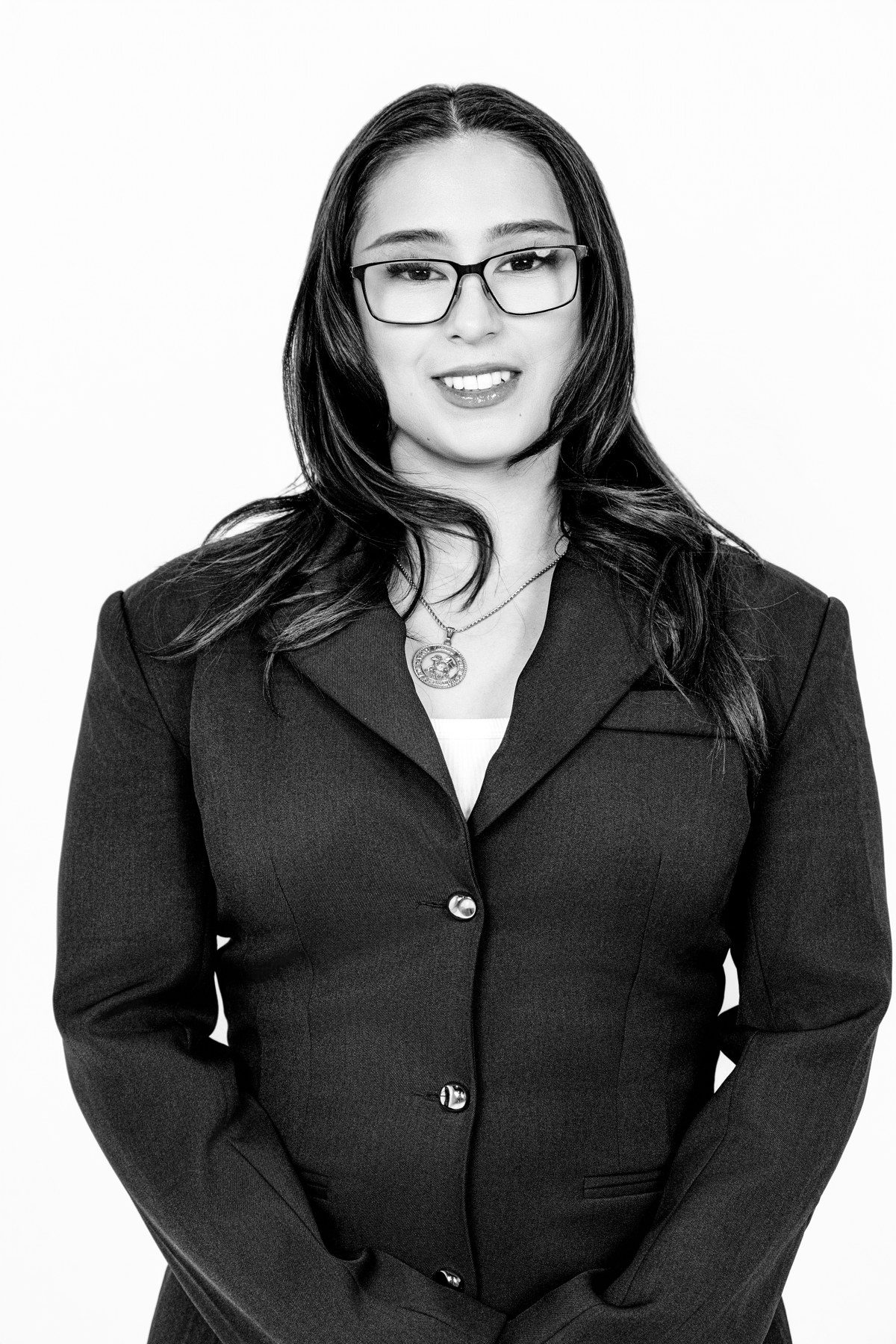 Black-and-white team portrait: team member wearing glasses and a dark collared blouse